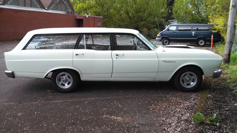1966 Ford Falcon wagon parked next to a dark blue van