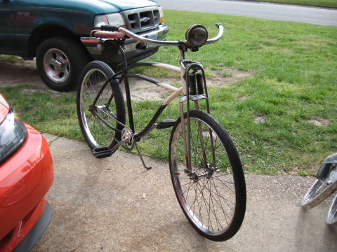 1994 Ford Bronco - A vintage bicycle is parked on a driveway, with parts of a green truck and a red car visible in the background.