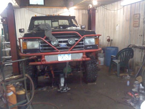 1995 Ford F-150 - This modified Ford F-Series truck is in a garage, possibly undergoing repairs or modifications.