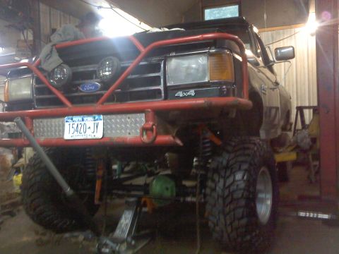 1995 Ford F-150 - This heavily modified 1995 Ford F-150 features a custom front bumper and suspension lift, indicating significant off-road enhancements.