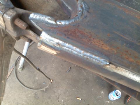 1995 Ford F-150 - Close-up of a heavily modified and welded metal frame component, likely part of a vehicle's suspension or chassis.