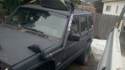 1998 Jeep Cherokee - This Jeep Cherokee is equipped with a snorkel for off-road use and has a spare tire mounted on its roof rack.