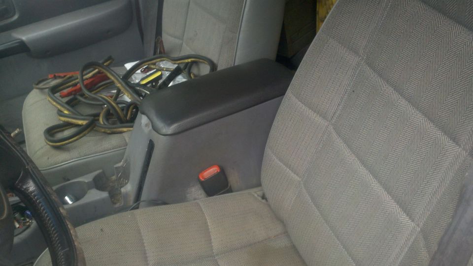 1998 Jeep Cherokee interior showing passenger seat, center console with armrest, and jumper cables on the driver's seat