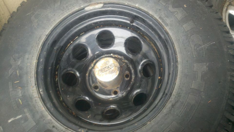 Black steel wheel with a tire, showing a center cap with 'CHACAR' text