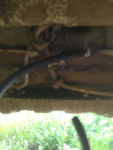 1979 Ford Bronco - A close-up view of a vehicle's undercarriage reveals a fuel line and associated hoses.