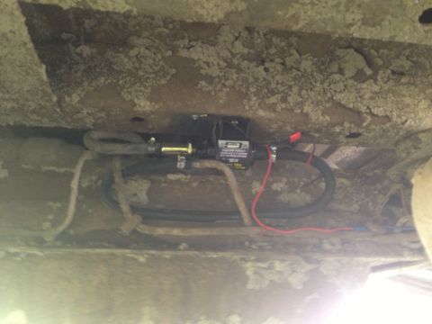 1979 Ford Bronco - Close-up of an aftermarket electric fuel pump installed on a vehicle's undercarriage.