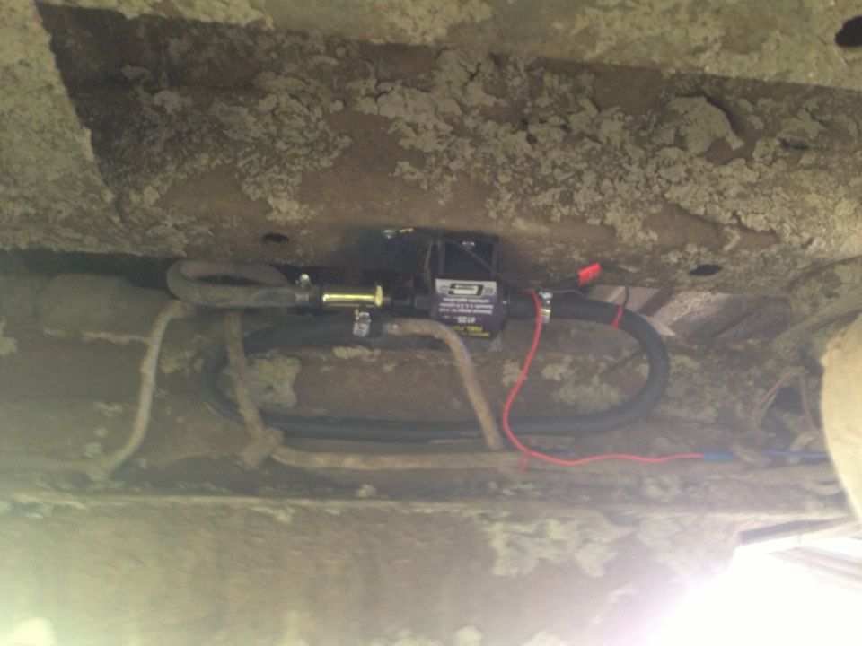 Electric fuel pump mounted under vehicle chassis with fuel lines and wiring
