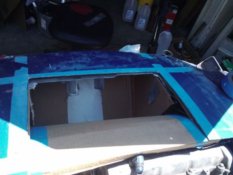 1995 Ford Probe - The car's roof has been taped off around a window opening, with cardboard visible inside.
