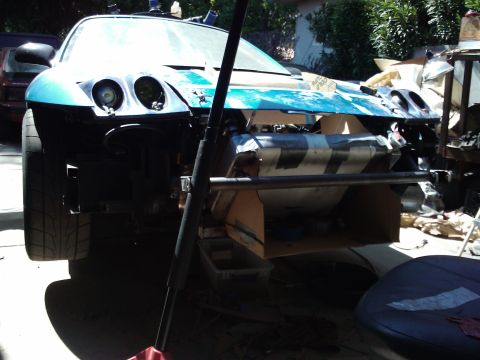 1995 Ford Probe - Front view of a 1995 Ford Probe undergoing repairs, with its hood and bumper removed.