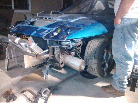 1995 Ford Probe - A blue car with its front end disassembled and hood removed is shown in a garage setting.