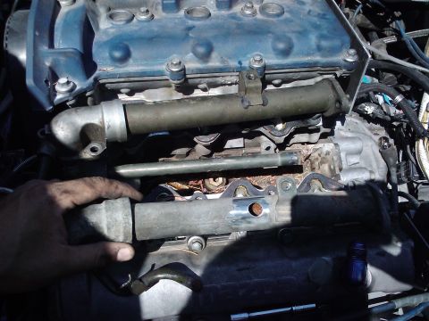 1995 Ford Probe - Close-up of engine parts, with a hand manipulating a metal tube.