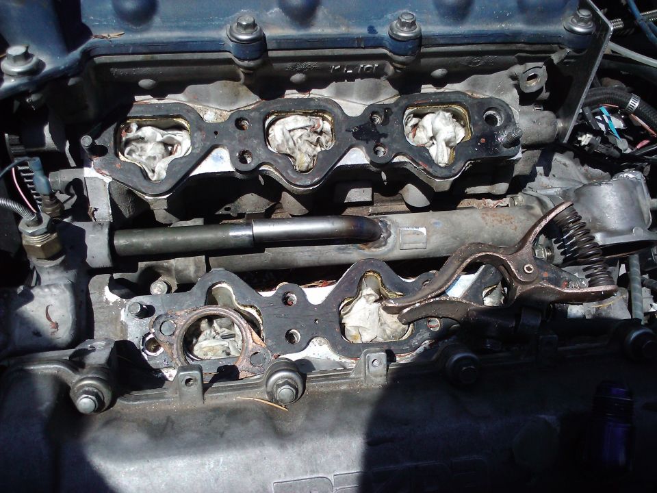 engine intake manifold gaskets removed, showing ports stuffed with rags