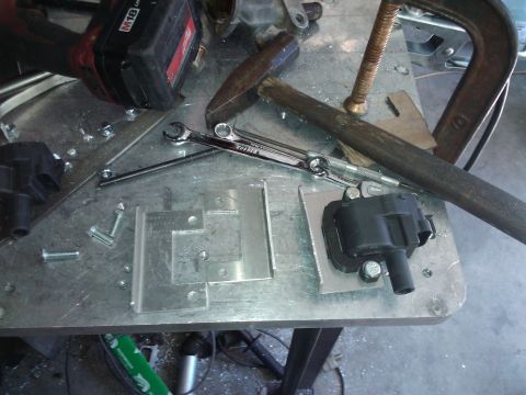 1995 Ford Probe - Automotive ignition coils and tools are laid out on a metal workbench for a repair or project.