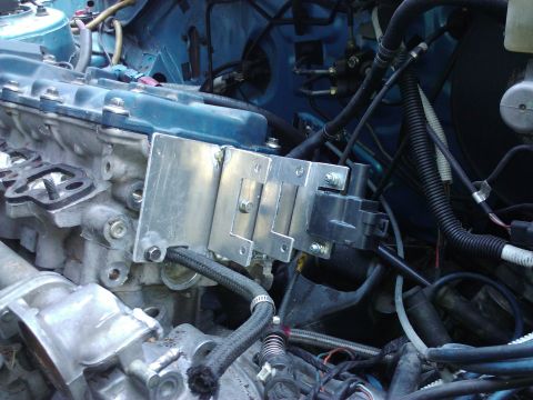 1995 Ford Probe - Close-up view of an engine bay, focusing on a custom-mounted ignition coil and associated wiring.