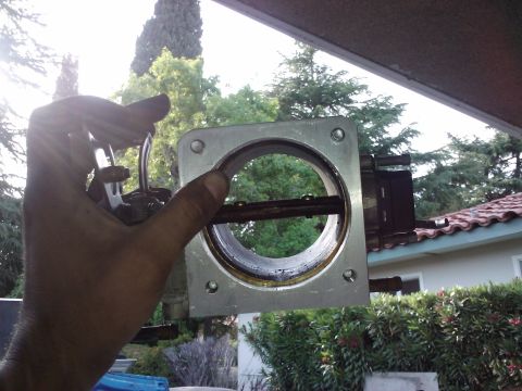 1995 Ford Probe - A dirty throttle body part is held up for inspection, with a website logo visible.