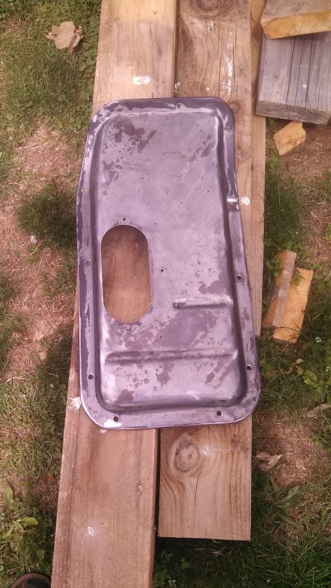 1979 Ford Bronco - Oil pan part shown on wooden planks outdoors.