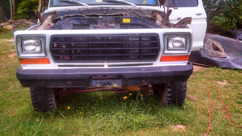Front view of a 1978 Ford Bronco with its hood open, showing a black grille and orange turn signals