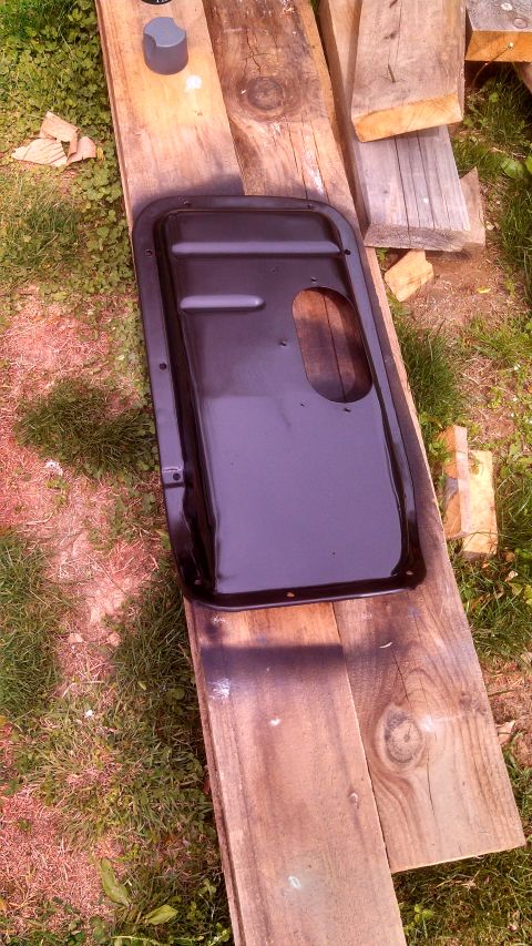 1979 Ford Bronco - A black oil pan, likely for a classic vehicle, is shown drying on wooden planks in an outdoor setting.