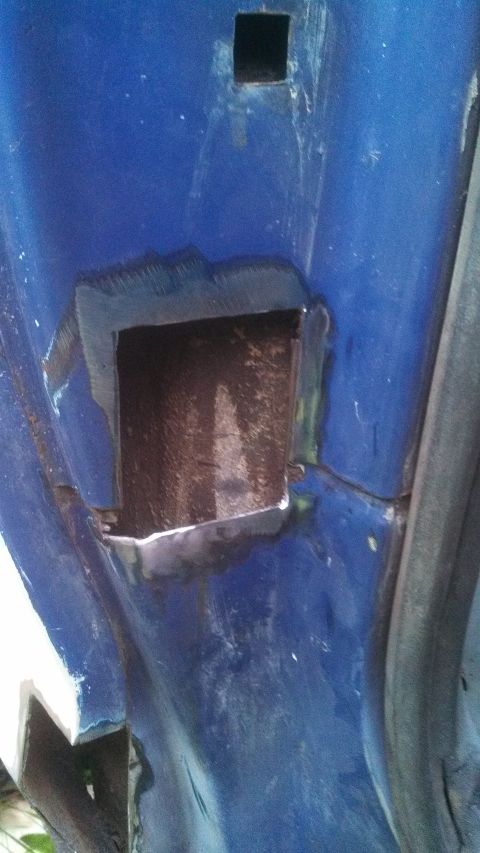 1979 Ford Bronco - Close-up of a blue vehicle's body panel with a freshly cut opening, revealing the underlying structure.