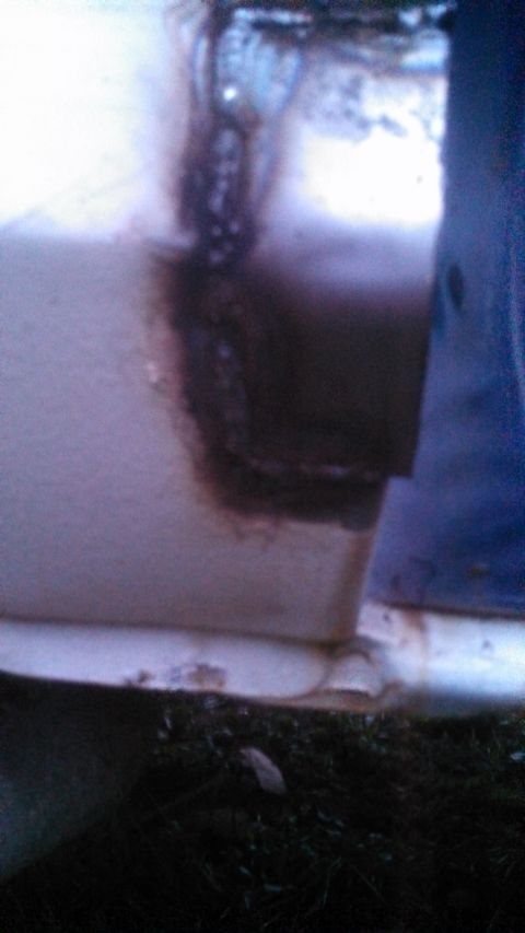 1979 Ford Bronco - Detail shot of corrosion on a vehicle's lower body panel, showing significant rust damage.