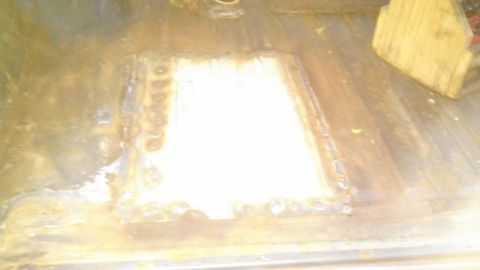 1979 Ford Bronco - A patch has been welded into place on a rusty metal surface, with a piece of wood visible nearby.
