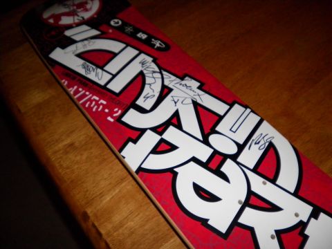 1997 Ford Probe - A red skateboard with bold white lettering and multiple signatures is displayed on a wooden table.