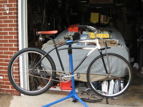 1994 Ford Bronco - A cruiser bicycle, painted black and white, is mounted on a blue repair stand in a garage setting.