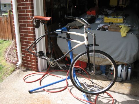 1994 Ford Bronco - A bicycle frame is mounted on a repair stand in a garage, with various items stored in the background.