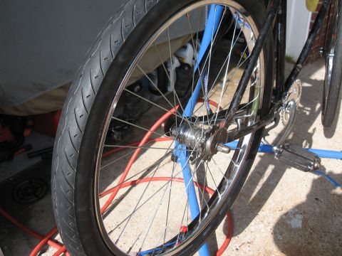 1994 Ford Bronco - Close-up view of a bicycle's rear wheel, hub, and chainring assembly, supported by a blue stand.