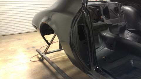 1972 Pontiac Trans Am - The interior and rear quarter panel of a black 1972 Pontiac Trans Am are visible, likely undergoing restoration.