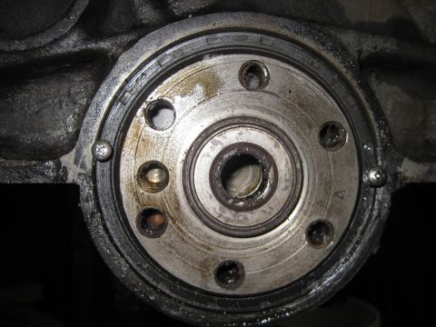 1989 Ford Bronco - This is a close-up view of an engine's crankshaft seal housing, showing wear and bolts.