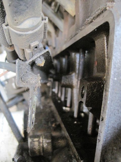1989 Ford Bronco - Close-up view of an engine's valve train, showing internal components and a damaged bracket.