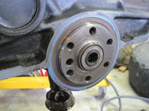 1989 Ford Bronco - Close-up view of an engine crankshaft seal, showing the metal component and blue sealant applied around its edge.