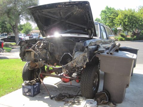 1989 Ford Bronco - Engine bay of a 1989 Ford Bronco, with the hood open, revealing the engine and cross member.