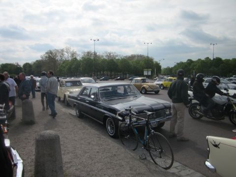 1991 Ford LTD Crown Victoria - A collection of vintage cars and motorcycles gathered outdoors under a cloudy sky.