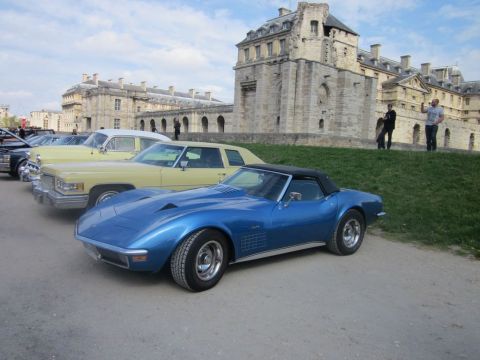 1991 Ford LTD Crown Victoria - Blue C3 Corvette convertible parked in front of a large stone building with other cars.