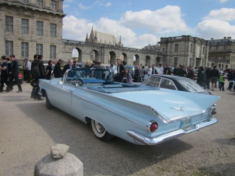 1991 Ford LTD Crown Victoria - A classic light blue convertible with prominent tail fins is parked in front of an ornate stone building.