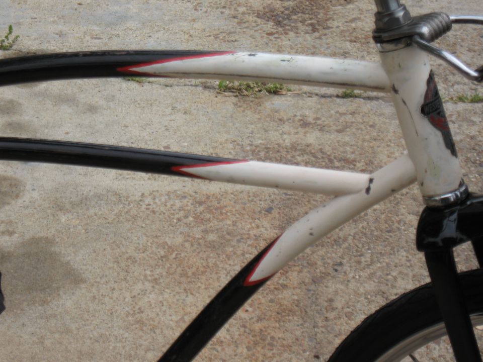 Close-up of a bicycle frame with black and white tubes and red accents