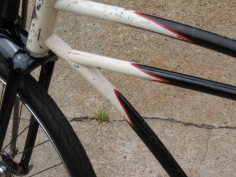 1994 Ford Bronco - The frame of a bicycle shows wear and tear with chipped paint and visible rust spots.