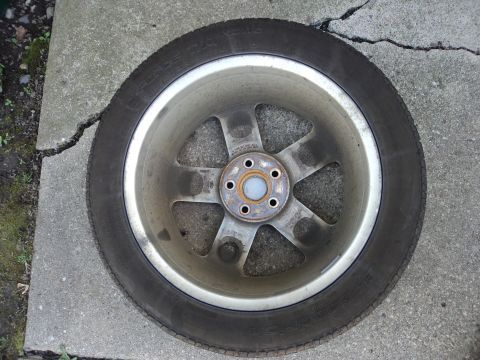 2004 Mercury Grand Marquis - A single car wheel and tire is shown on a cracked concrete surface.