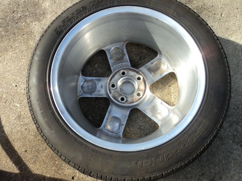 2004 Mercury Grand Marquis - A close-up view of a single tire and wheel assembly resting on a concrete surface.