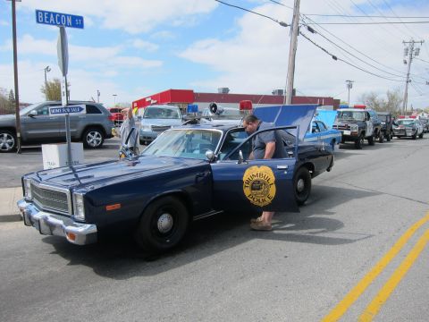 1991 Ford Crown Victoria - A line of police cars are parked on a street with a Beacon St sign visible.