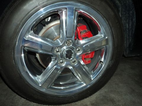 2004 Mercury Grand Marquis - Close-up of a chrome wheel with a red brake caliper and a Mercury emblem on the hub.