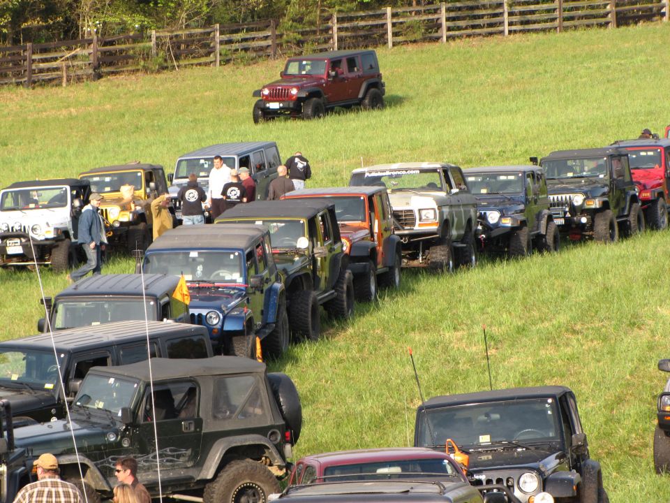 White Ford Bronco with a lifted suspension, parked in a line of Jeeps