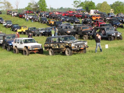 1979 Ford Bronco - A gathering of off-road vehicles, including a Jeep Cherokee, parked on a grassy field.