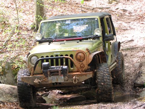 1979 Ford Bronco - Off-road Jeep Wrangler navigating a challenging muddy path.