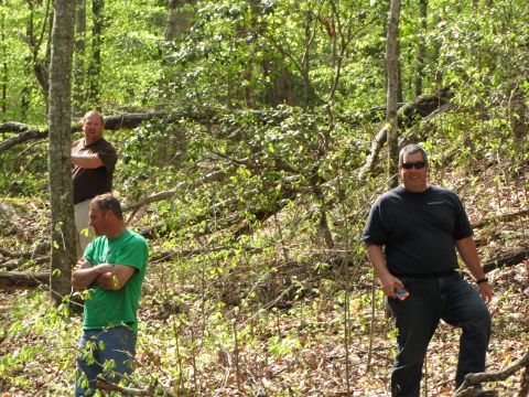 1979 Ford Bronco - Three men are in a wooded area. The man in the foreground wears a black t-shirt and sunglasses.