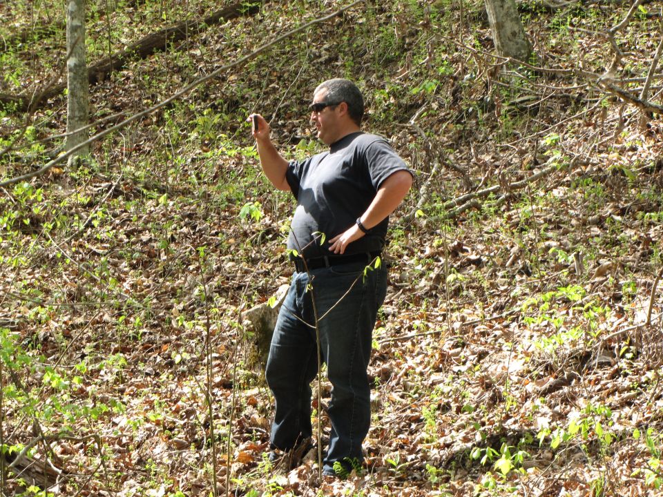 Man holding phone in wooded area