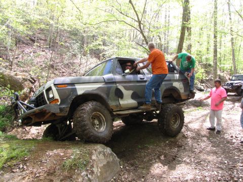 1979 Ford Bronco - This off-road vehicle, likely a 1978 Ford Bronco, is being assisted by onlookers while traversing a rocky trail.