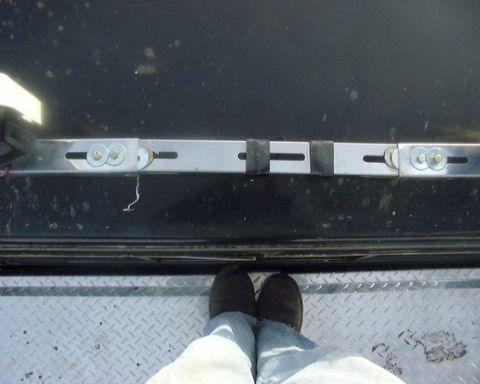 1985 Ford F-150 - Metal light bar mounting hardware is shown attached to a black surface.